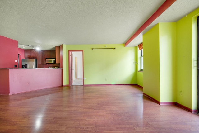401 1st St Unit 401, Minneapolis, MN 55401 - unfurnished living room featuring a textured ceiling, wood finished floors, and baseboards