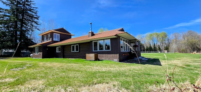 view of side of home with metal roof and a lawn