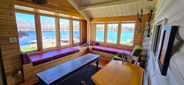 sunroom with a water view, wood ceiling, and wooden walls