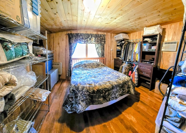 bedroom featuring wood finished floors, wood ceiling, a wall mounted AC, and wooden walls