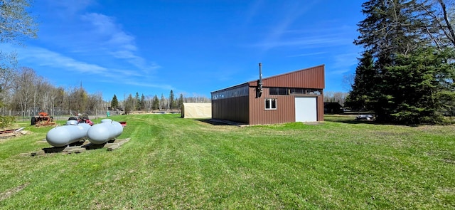 view of green lawn with an outdoor structure, a pole building, and a detached garage