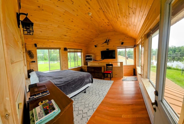 17801 Bear Crk, Angle Inlet, MN 56711 - bedroom with wooden walls, vaulted ceiling, access to exterior, multiple windows, and wood finished floors
