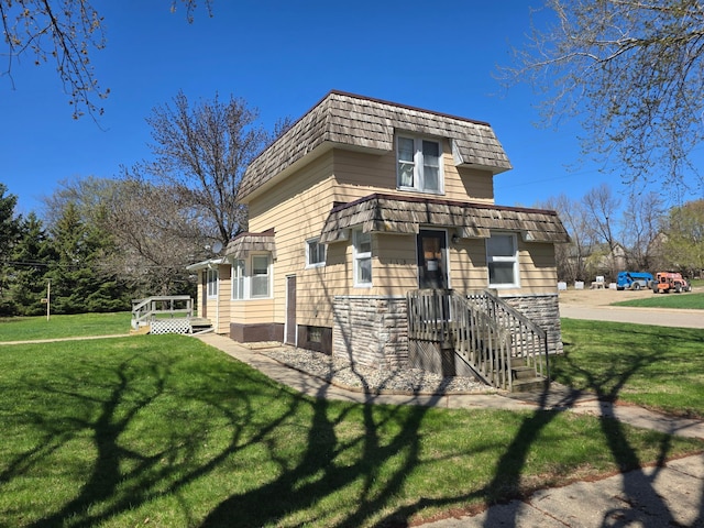 view of side of property with a lawn and mansard roof