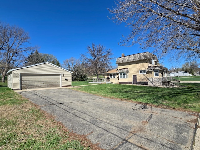 view of side of property with a yard, a chimney, an outdoor structure, and a garage