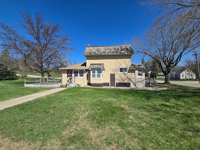 view of front of property with a front lawn, a wooden deck, and a chimney