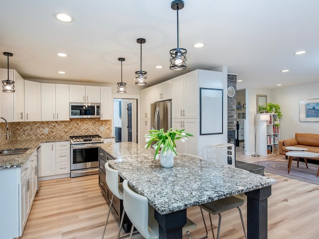 2415 Edgerton St, Little Canada, MN 55117 - kitchen with stainless steel appliances, a sink, a center island, light stone counters, and recessed lighting