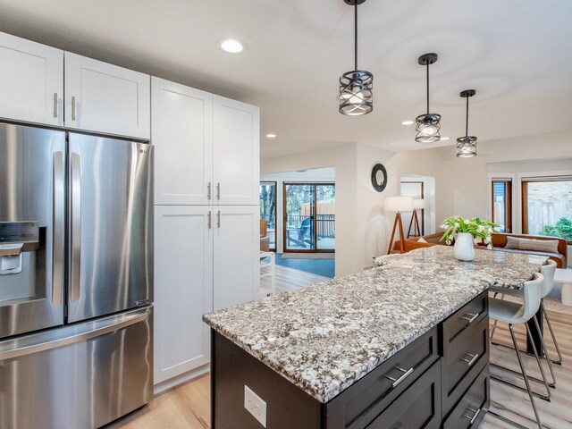2415 Edgerton St, Little Canada, MN 55117 - kitchen featuring stainless steel fridge with ice dispenser, a kitchen island, white cabinetry, light stone countertops, and recessed lighting