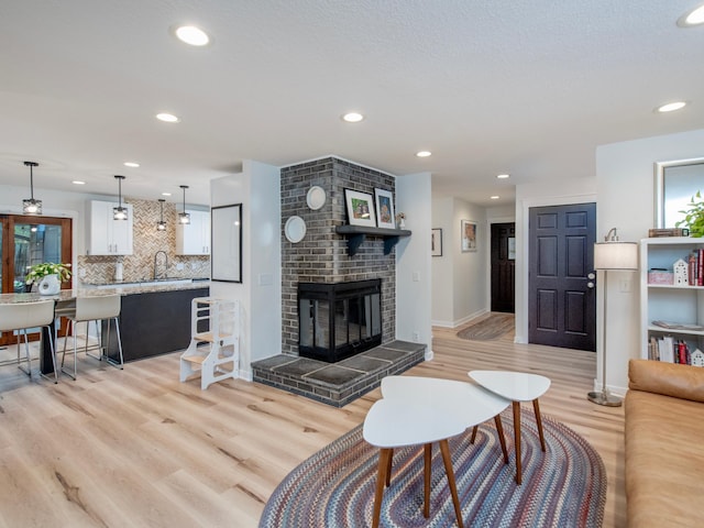 2415 Edgerton St, Little Canada, MN 55117 - living area with light wood-style flooring, recessed lighting, a fireplace, and baseboards