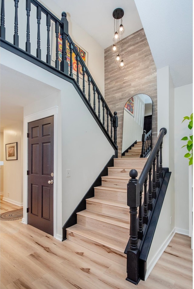 2415 Edgerton St, Little Canada, MN 55117 - stairs featuring wood finished floors, baseboards, a high ceiling, and arched walkways