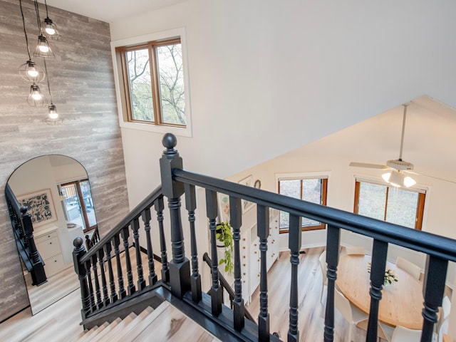 2415 Edgerton St, Little Canada, MN 55117 - stairs featuring an accent wall, wooden walls, wood finished floors, and a high ceiling