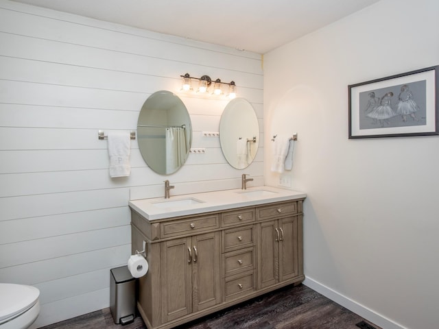2415 Edgerton St, Little Canada, MN 55117 - full bath with wood finished floors, double vanity, toilet, and baseboards