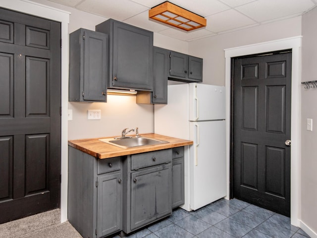 2415 Edgerton St, Little Canada, MN 55117 - kitchen with freestanding refrigerator, wood counters, gray cabinetry, a sink, and tile patterned flooring