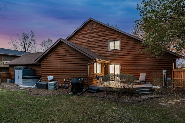 2415 Edgerton St, Little Canada, MN 55117 - back of property at dusk featuring a wooden deck, a garage, and central AC unit