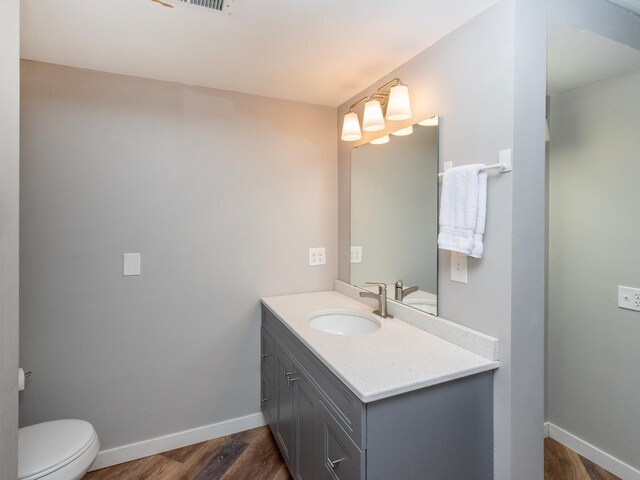2415 Edgerton St, Little Canada, MN 55117 - bathroom featuring vanity, wood finished floors, toilet, and baseboards