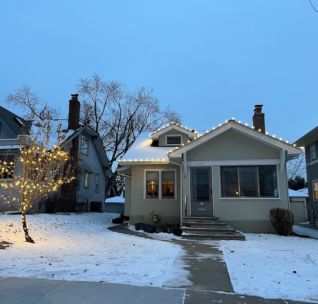 bungalow-style house featuring entry steps, a chimney, and central AC