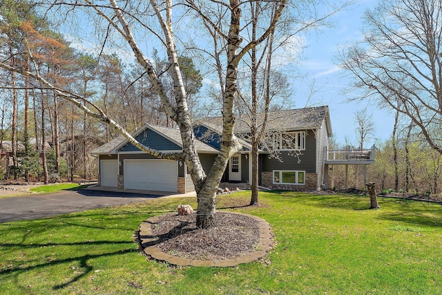 23465 7th St NE, East Bethel, MN 55005 - view of front facade featuring brick siding, a garage, aphalt driveway, a front yard, and a balcony