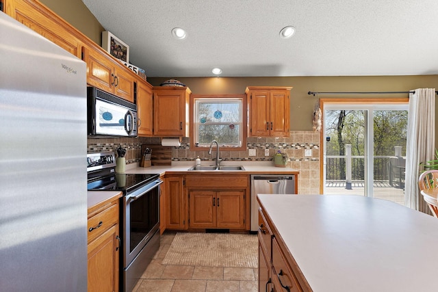 23465 7th St NE, East Bethel, MN 55005 - kitchen featuring light countertops, appliances with stainless steel finishes, decorative backsplash, and a sink