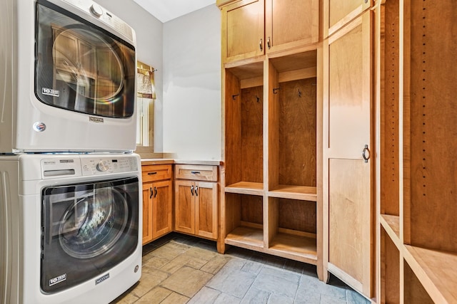 206 Fairway Cir, Glencoe, MN 55336 - laundry area featuring stacked washer / drying machine, cabinet space, and stone tile floors