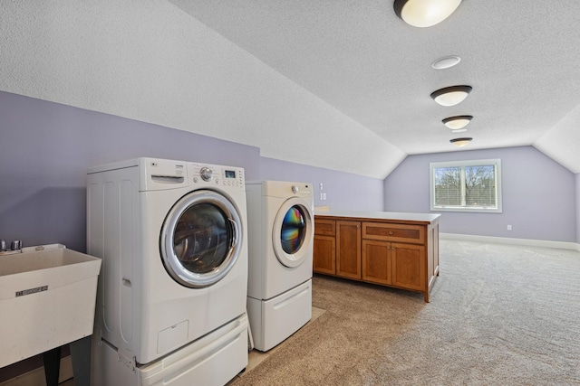 206 Fairway Cir, Glencoe, MN 55336 - laundry area featuring washer and clothes dryer, light carpet, a textured ceiling, and cabinet space