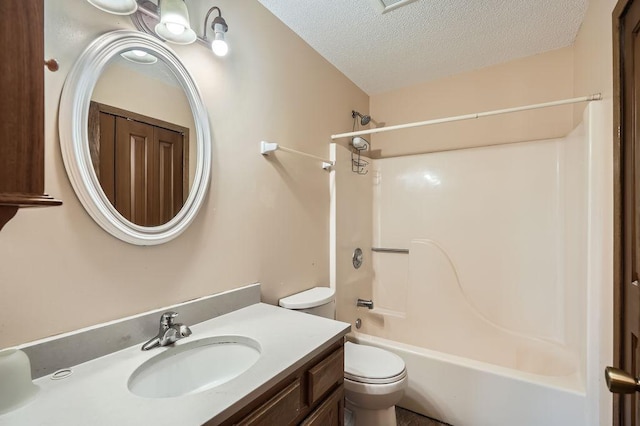 full bath with vanity, a textured ceiling, bathtub / shower combination, and toilet