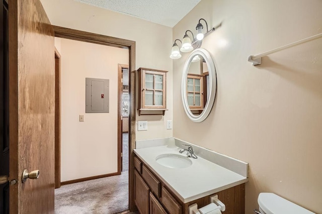 bathroom with vanity, a textured ceiling, electric panel, and toilet
