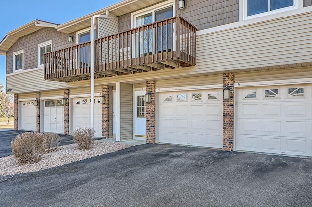 exterior space with driveway, a balcony, and a garage