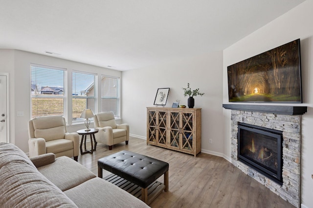 10054 Mulberry Ln, Corcoran, MN 55374 - living room with a stone fireplace, baseboards, light wood-type flooring, and visible vents