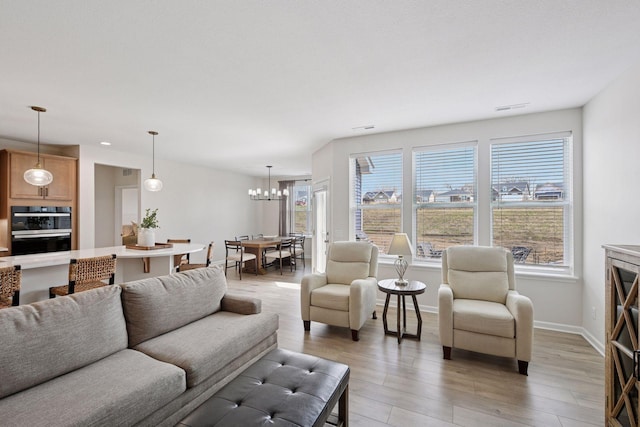 10054 Mulberry Ln, Corcoran, MN 55374 - living room with light wood-type flooring, a chandelier, baseboards, and visible vents