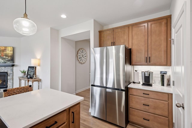 10054 Mulberry Ln, Corcoran, MN 55374 - kitchen with freestanding refrigerator, light countertops, brown cabinetry, and light wood-type flooring