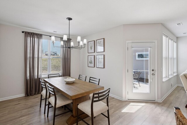10054 Mulberry Ln, Corcoran, MN 55374 - dining room featuring baseboards, a wealth of natural light, a chandelier, and light wood-style flooring