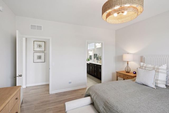 10054 Mulberry Ln, Corcoran, MN 55374 - bedroom featuring connected bathroom, visible vents, baseboards, light wood-style floors, and a chandelier