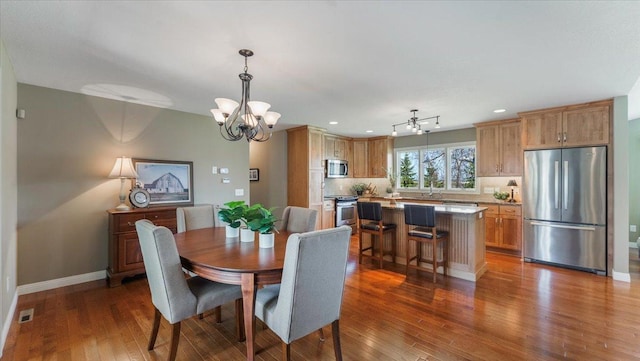 dining area with visible vents, baseboards, a notable chandelier, recessed lighting, and hardwood / wood-style floors