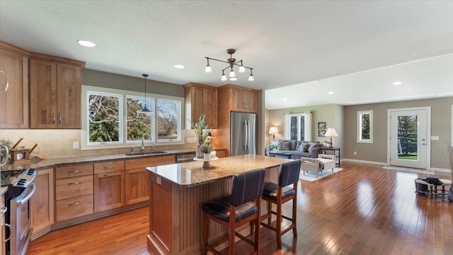 kitchen featuring open floor plan, appliances with stainless steel finishes, a wealth of natural light, and a sink
