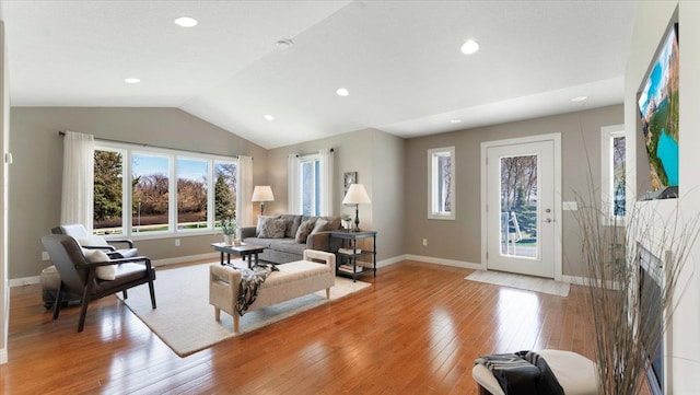 living area with light wood-type flooring, recessed lighting, baseboards, and lofted ceiling