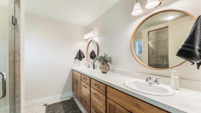 full bath featuring a sink, baseboards, a stall shower, and double vanity