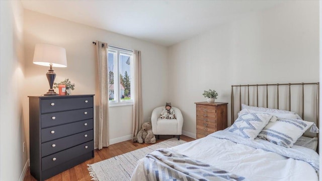 bedroom with baseboards and wood finished floors