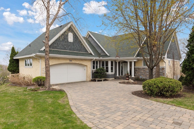 1360 Skyline Dr, Golden Valley, MN 55422 - view of front of house with roof with shingles, an attached garage, stucco siding, a front yard, and decorative driveway