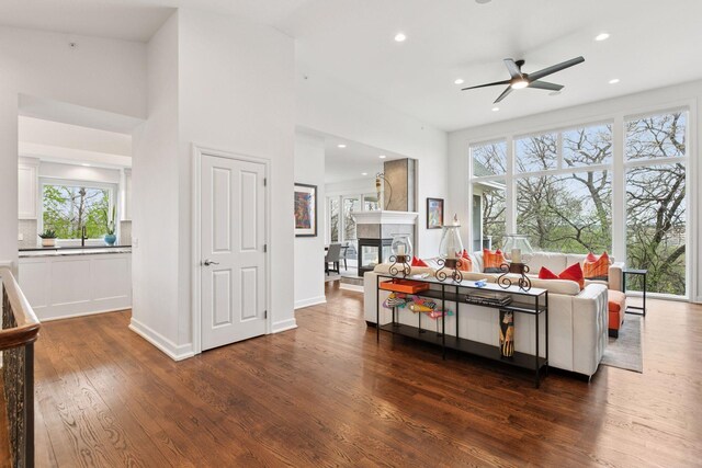 1360 Skyline Dr, Golden Valley, MN 55422 - living room with a multi sided fireplace, dark wood-style flooring, a ceiling fan, and recessed lighting