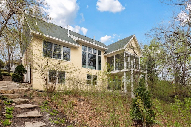 1360 Skyline Dr, Golden Valley, MN 55422 - rear view of house featuring a sunroom, stucco siding, and roof with shingles