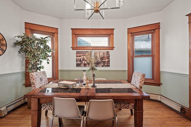 1005 Mclean Ave, Saint Paul, MN 55106 - dining area featuring a chandelier, a baseboard heating unit, and light wood-style floors