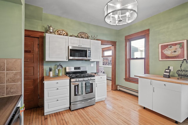 1005 Mclean Ave, Saint Paul, MN 55106 - kitchen featuring stainless steel appliances, a baseboard radiator, white cabinetry, and light wood-style flooring