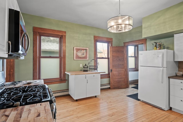 1005 Mclean Ave, Saint Paul, MN 55106 - kitchen featuring stainless steel appliances, white cabinets, a chandelier, a baseboard heating unit, and light wood-style floors