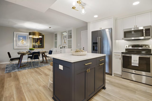 4075 51st St Unit 302, Edina, MN 55424 - kitchen featuring appliances with stainless steel finishes, white cabinets, light wood-type flooring, a center island, and recessed lighting