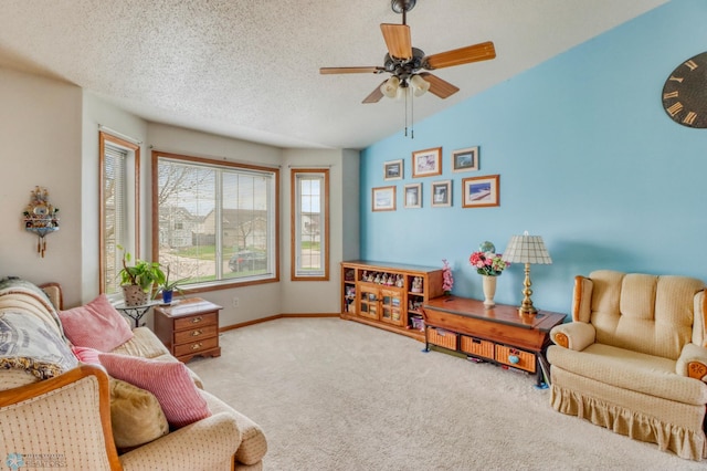 living room featuring carpet floors, a textured ceiling, baseboards, and ceiling fan