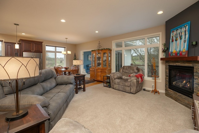 living room featuring recessed lighting, carpet flooring, baseboards, and a stone fireplace