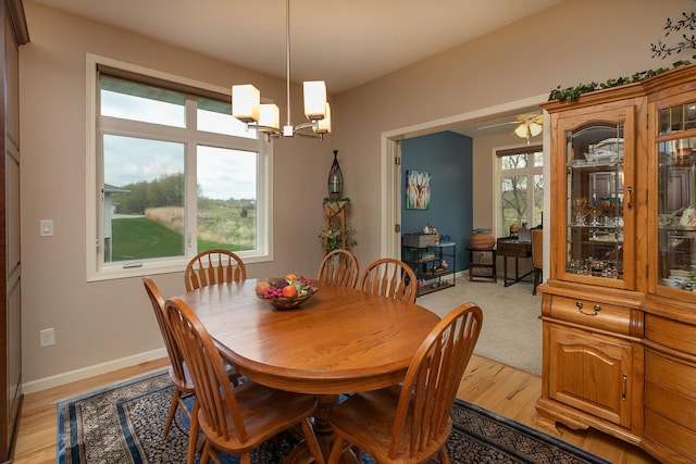 dining room featuring an inviting chandelier, baseboards, and light wood-type flooring