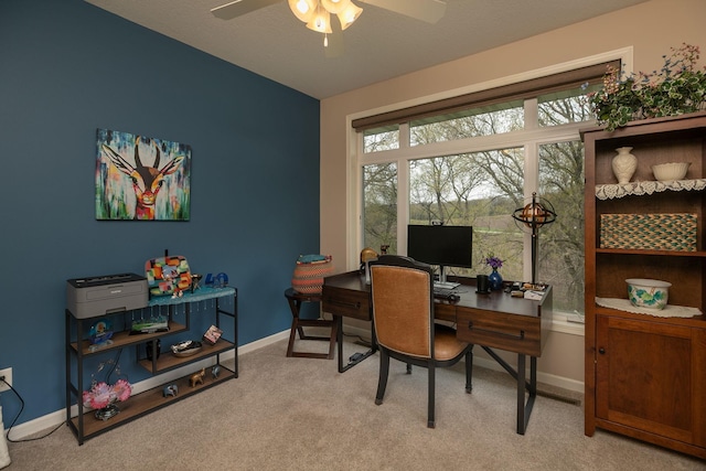 home office with baseboards, ceiling fan, and light carpet