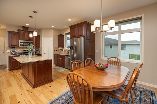 dining room with an inviting chandelier, baseboards, recessed lighting, and light wood-style flooring