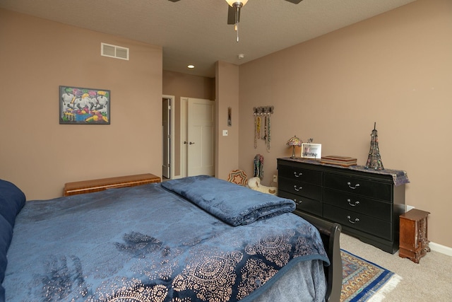 bedroom with a ceiling fan, visible vents, and light carpet