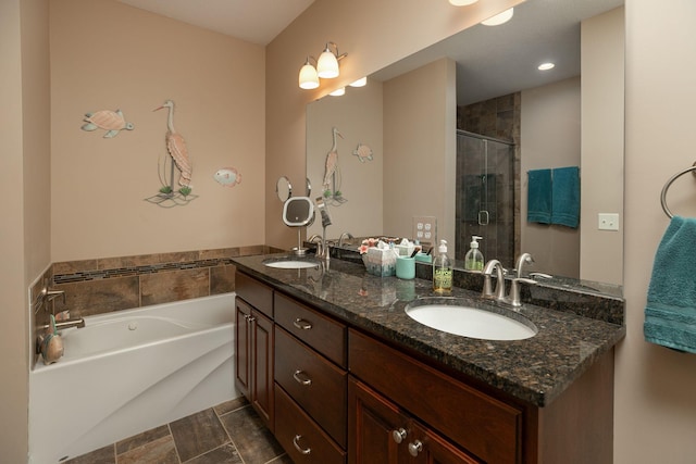 bathroom featuring a sink, double vanity, a stall shower, and a garden tub